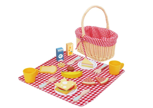 Coș de picnic pentru copii cu farfurii, căni, tacâmuri și alimente din lemn.
